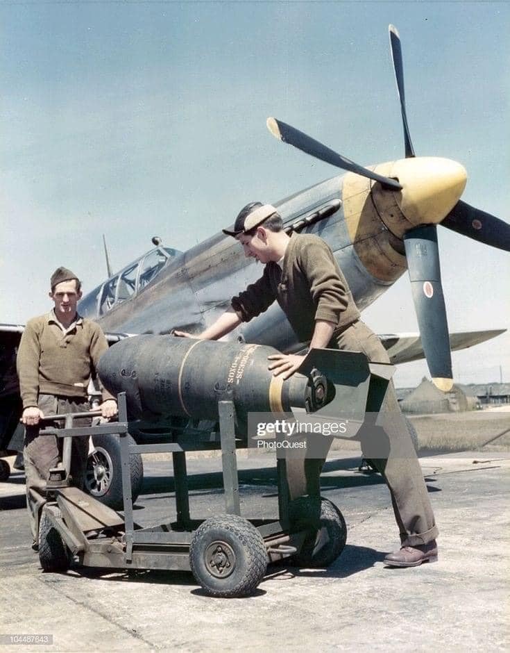 Armourers loading ordnance onto a P-51 fighter..jpg